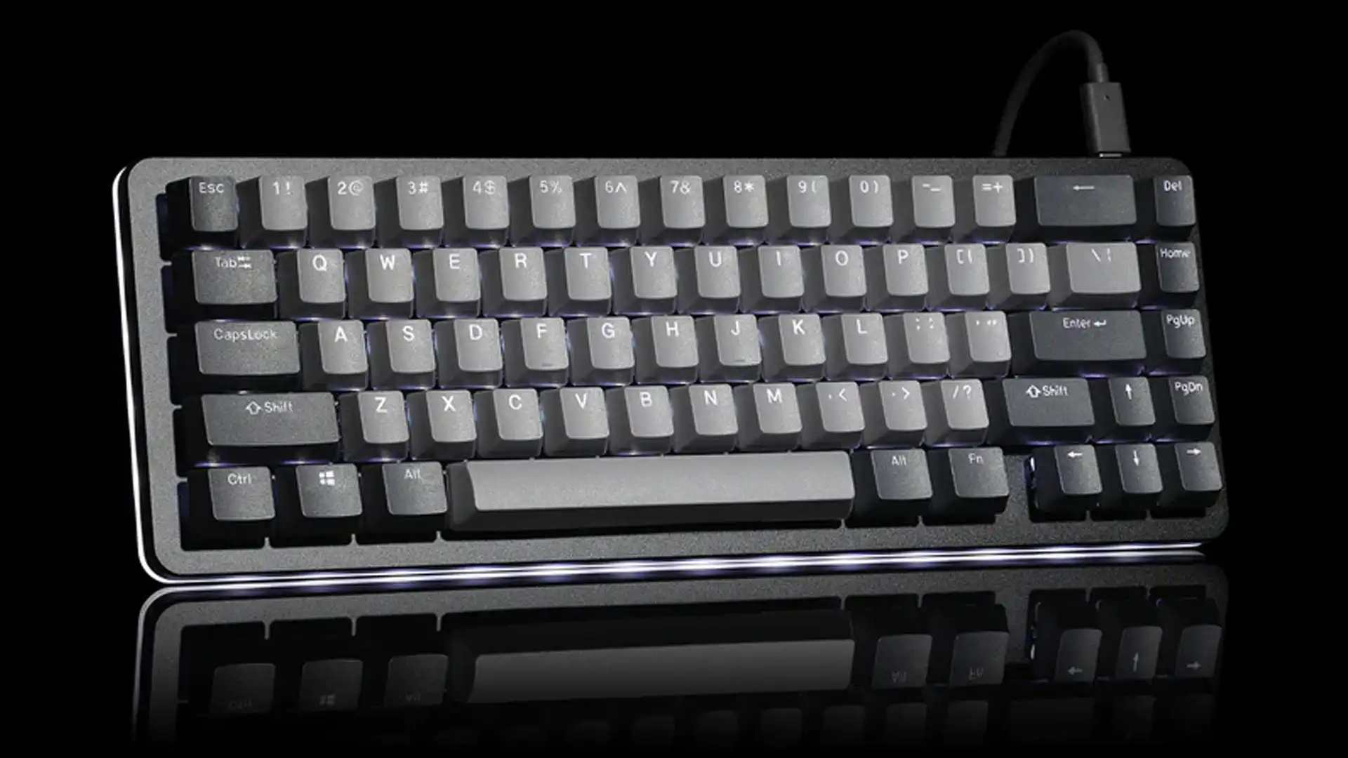 Compact mechanical keyboard with gray keycaps and backlighting on a black reflective surface